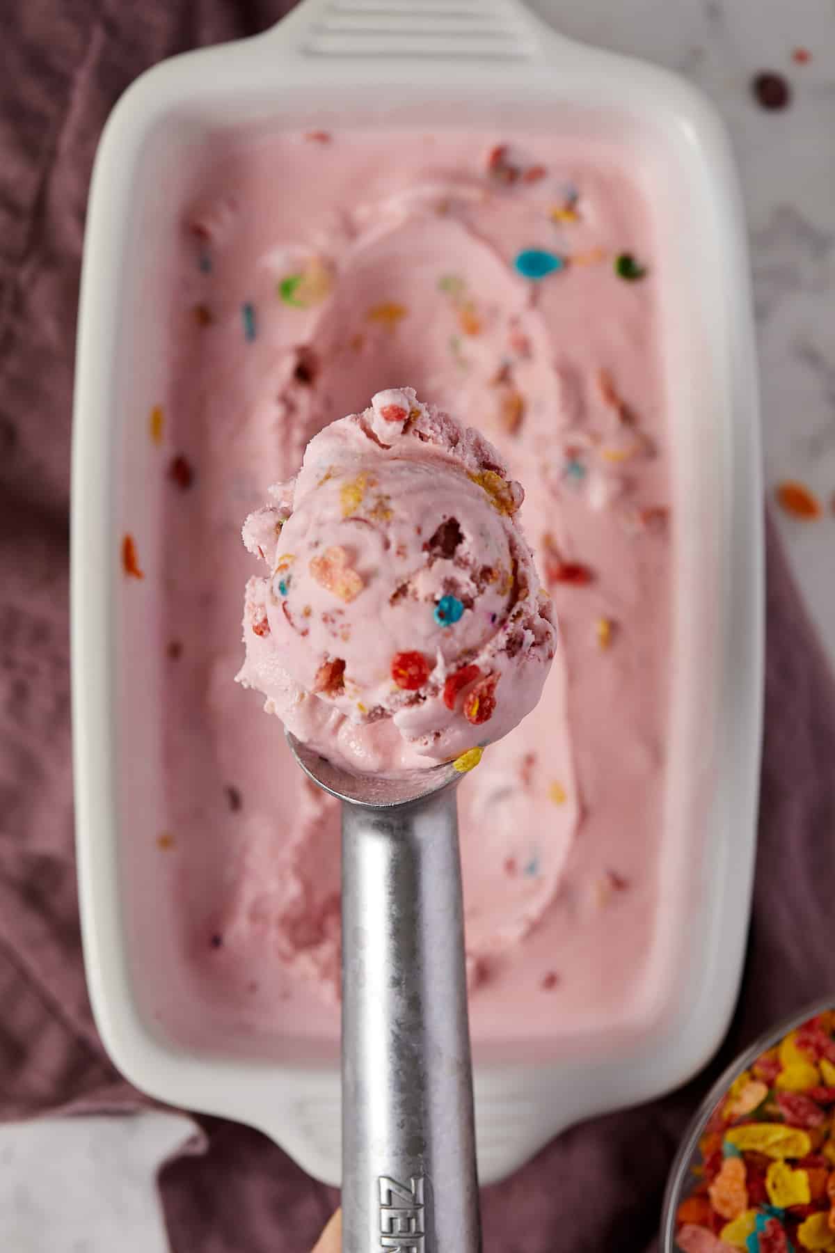 Overhead view of fruity pebble ice cream on a scoop.