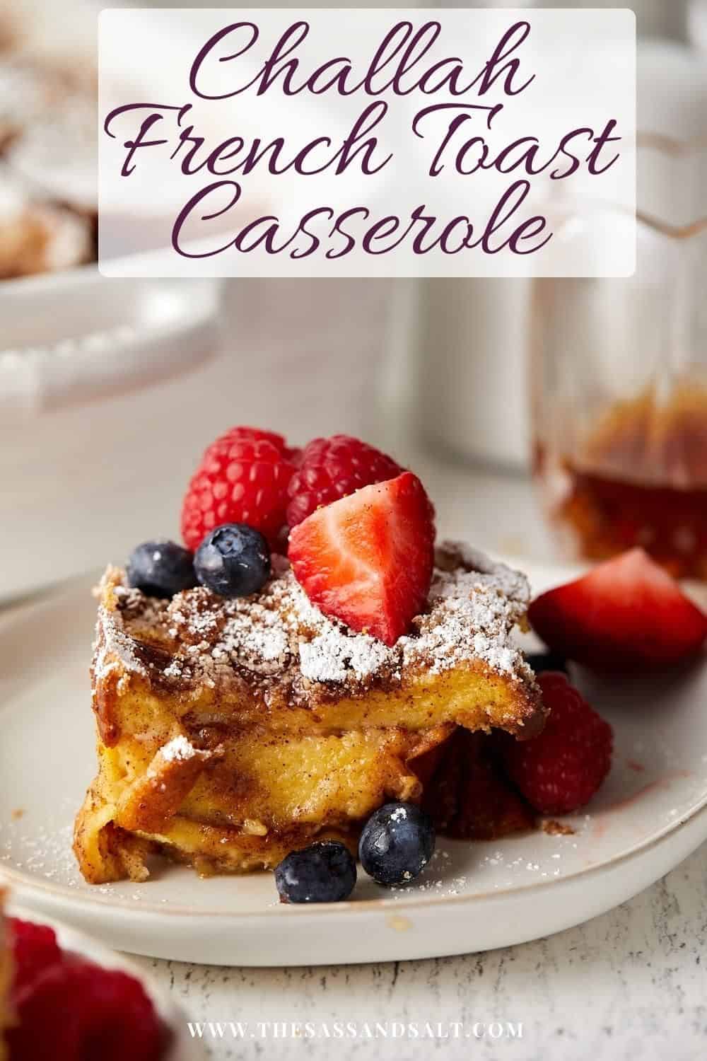 Close up view of challah french toast casserole on a plate with fruit on top.