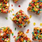 Overhead, view fruity pebbles and marshmallow treats cut into squares.