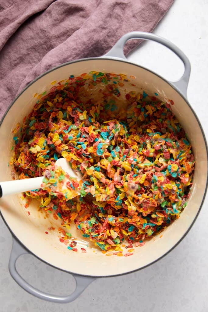 Overhead view fruity pebbles mixed with melted marshmallows.