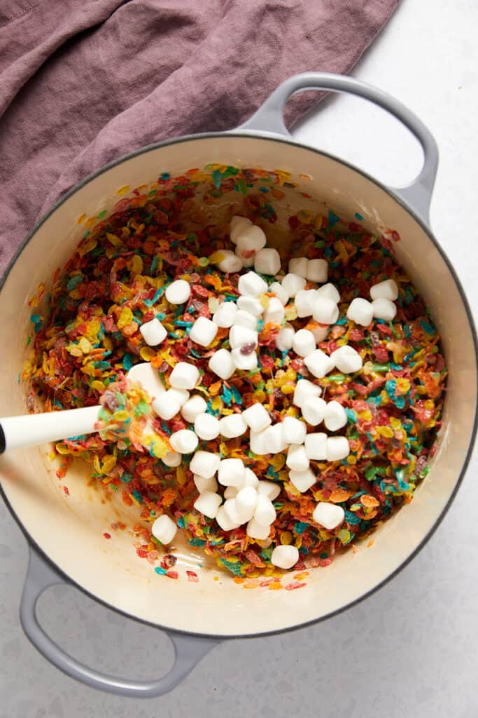 A cup of marshmallows poured on top of fruity pebbles marshmallow mix.