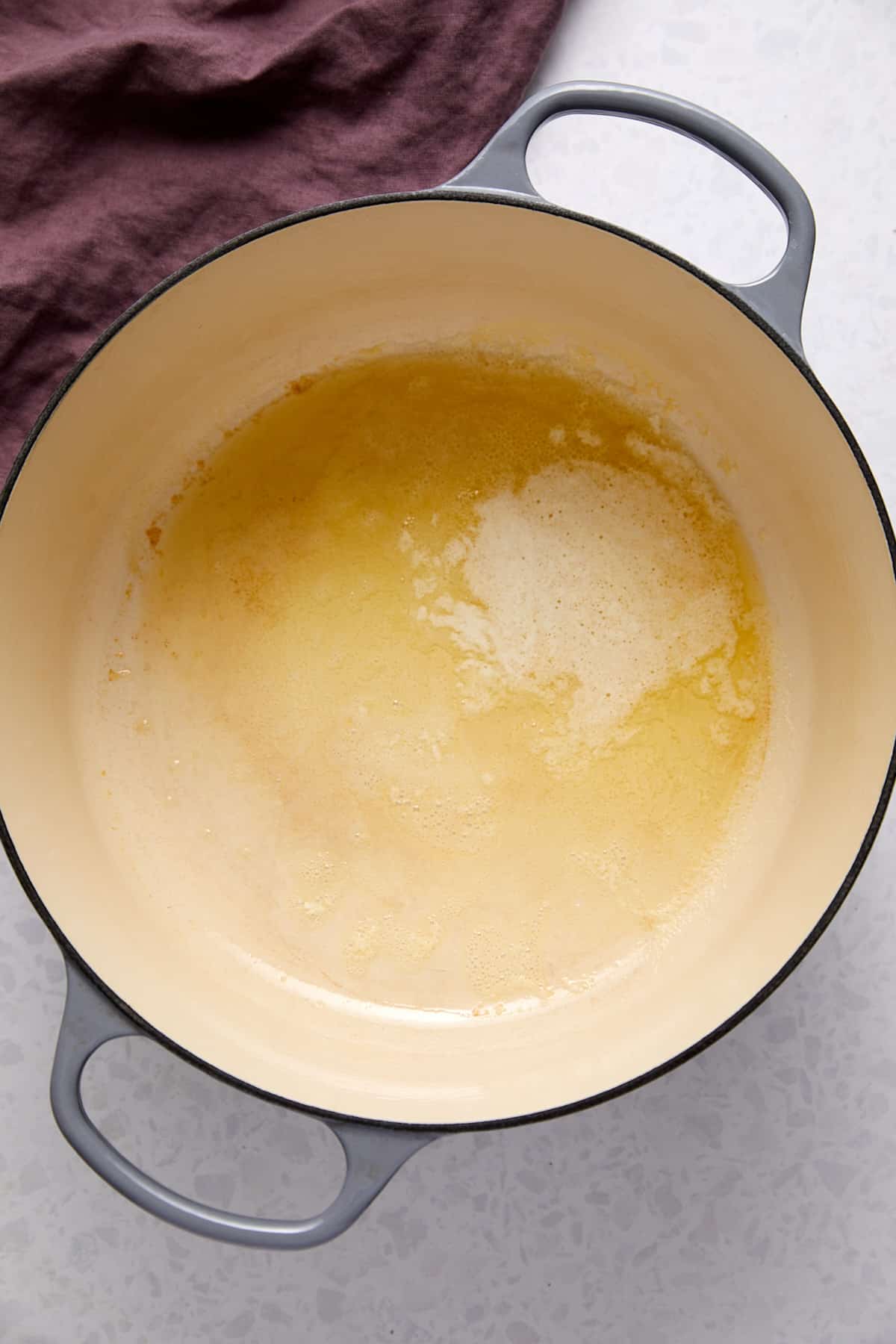 Overhead view of melted butter in a Dutch oven.
