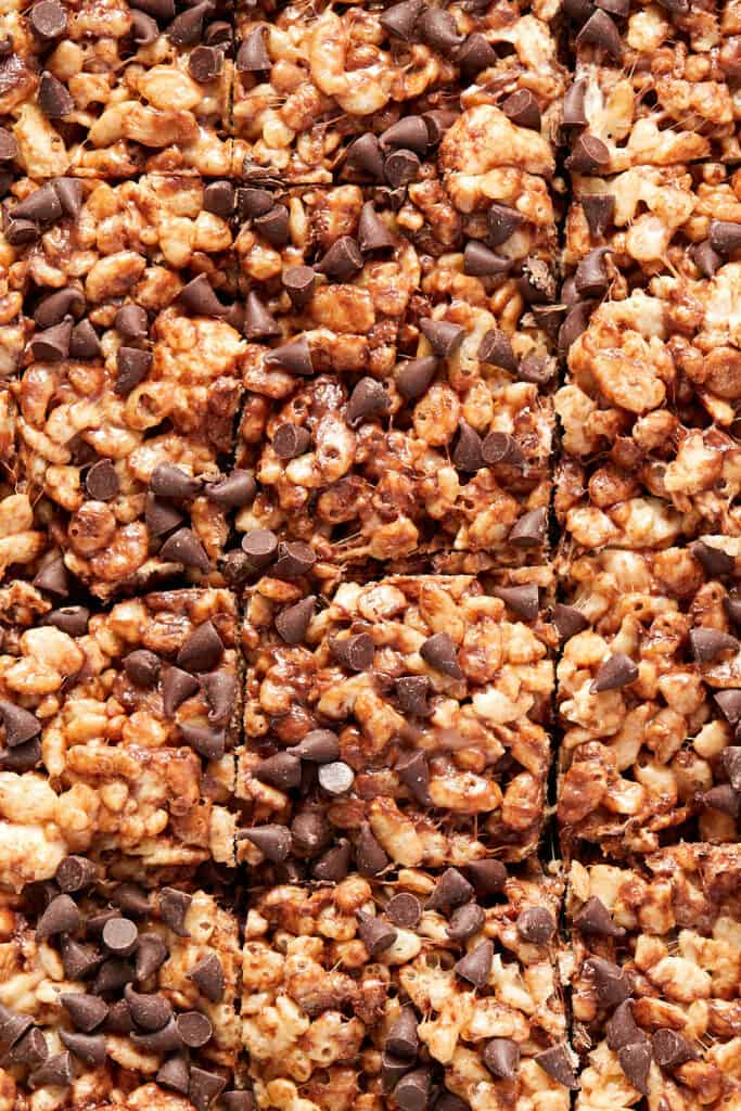 Close-up view of cut Chocolate Chip Rice Krispie Treats in a pan. 