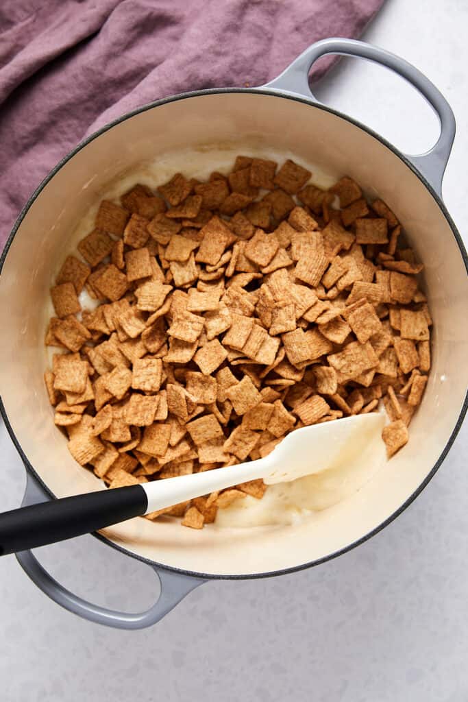 Overhead view of cinnamon toast crunch cereal on top of melted marshmallows.