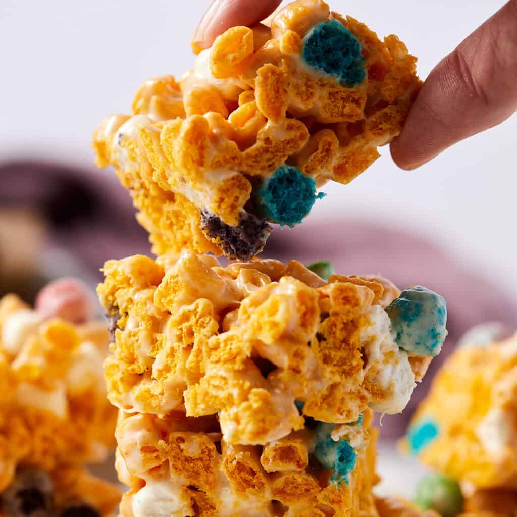 Close-up view of a stack of Captain Crunch marshmallow treats with the top one lifted off.