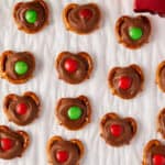 Overhead view of reindeer noses (rolo pretzel bites) on white parchment paper.