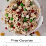 Overhead view of white chocolate Christmas Chex mix in a Christmas tin lined with white parchment paper.