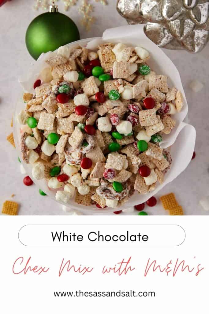 Overhead view of white chocolate Christmas Chex mix in a Christmas tin lined with white parchment paper.