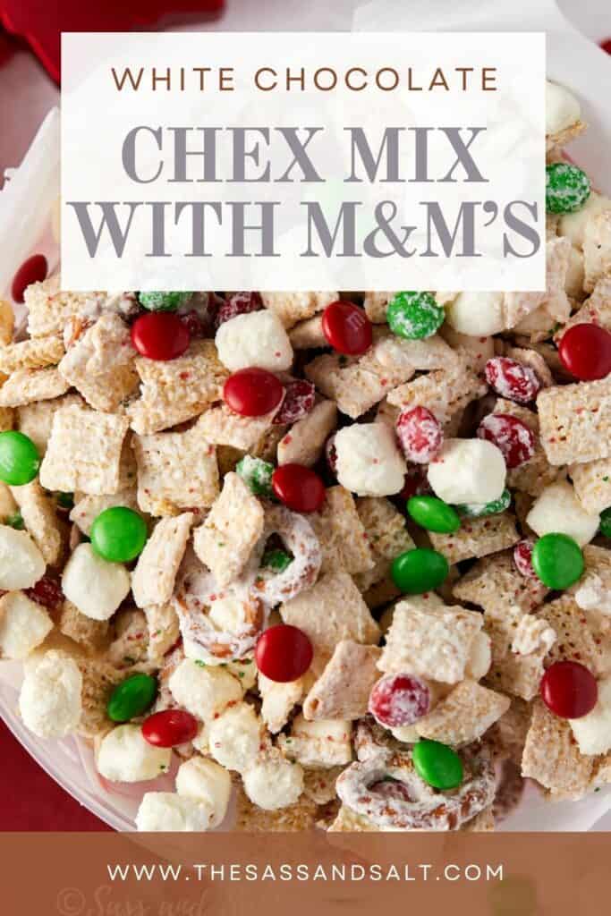 Overhead view of white chocolate Christmas Chex mix in a Christmas tin lined with white parchment paper.