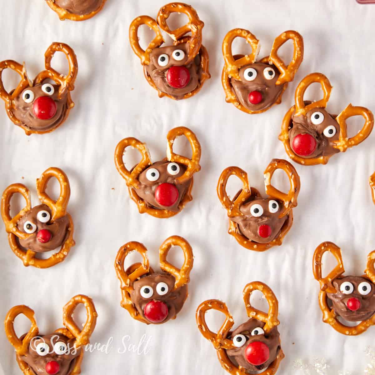 Overhead view of homemade pretzel reindeer with Rolo treats with antlers, eyes, and red noses.