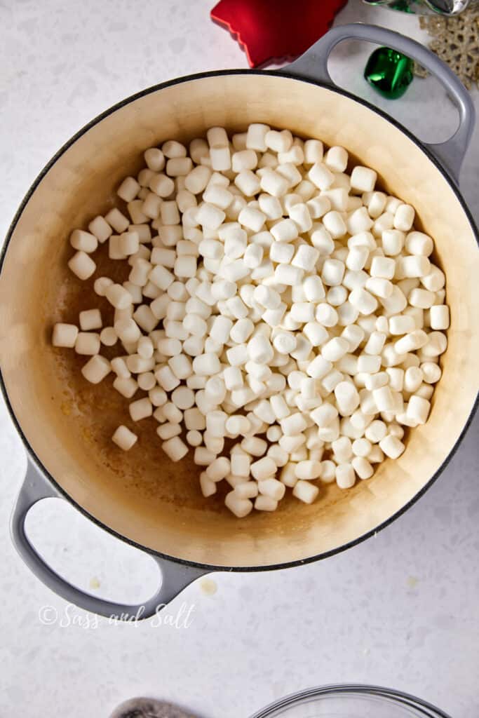 Overhead view of marshmallows in melted butter in dutch oven.