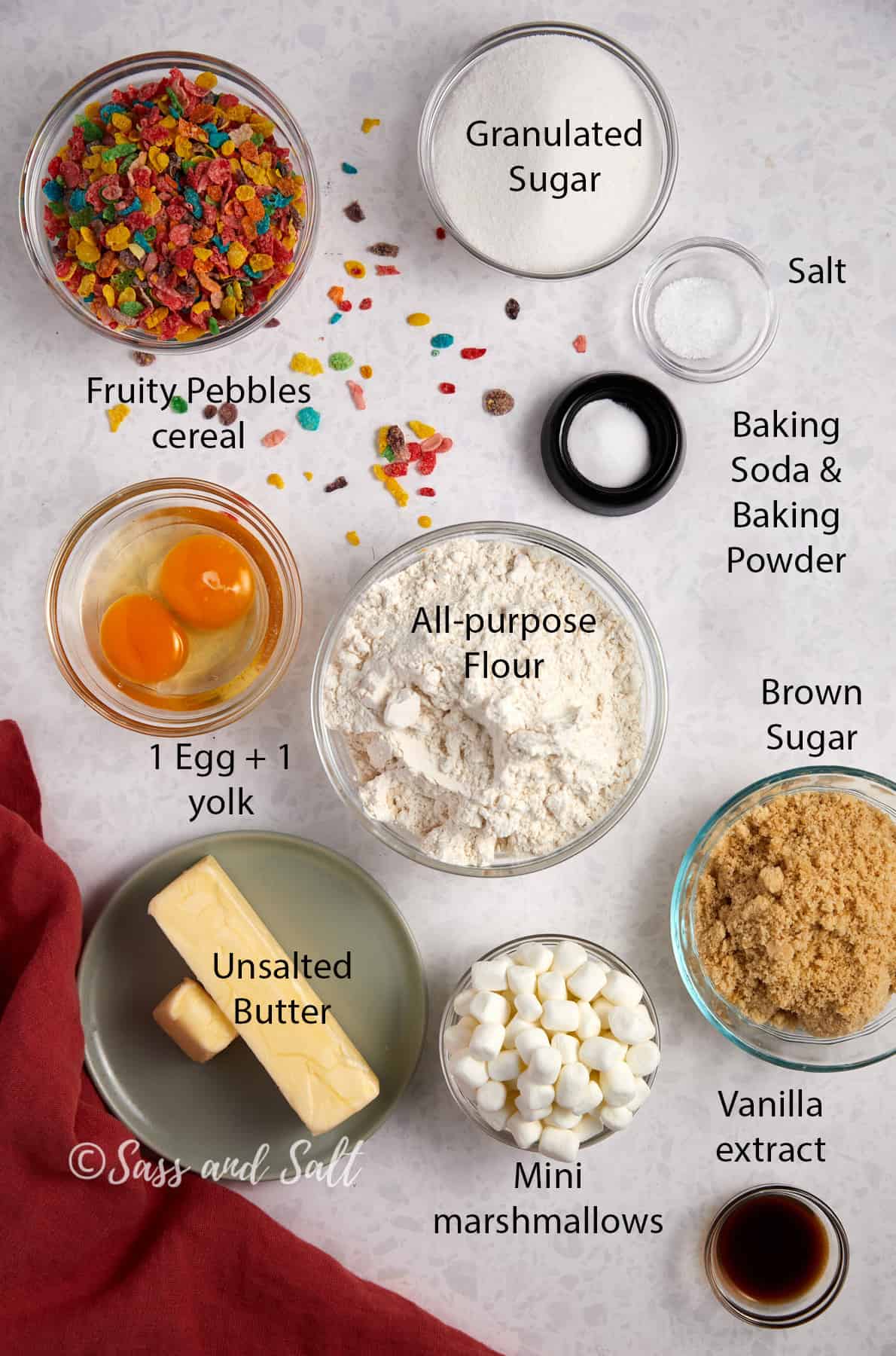 Overhead view of fruity pebbles marshmallow cookies ingredients laying on a white background. 