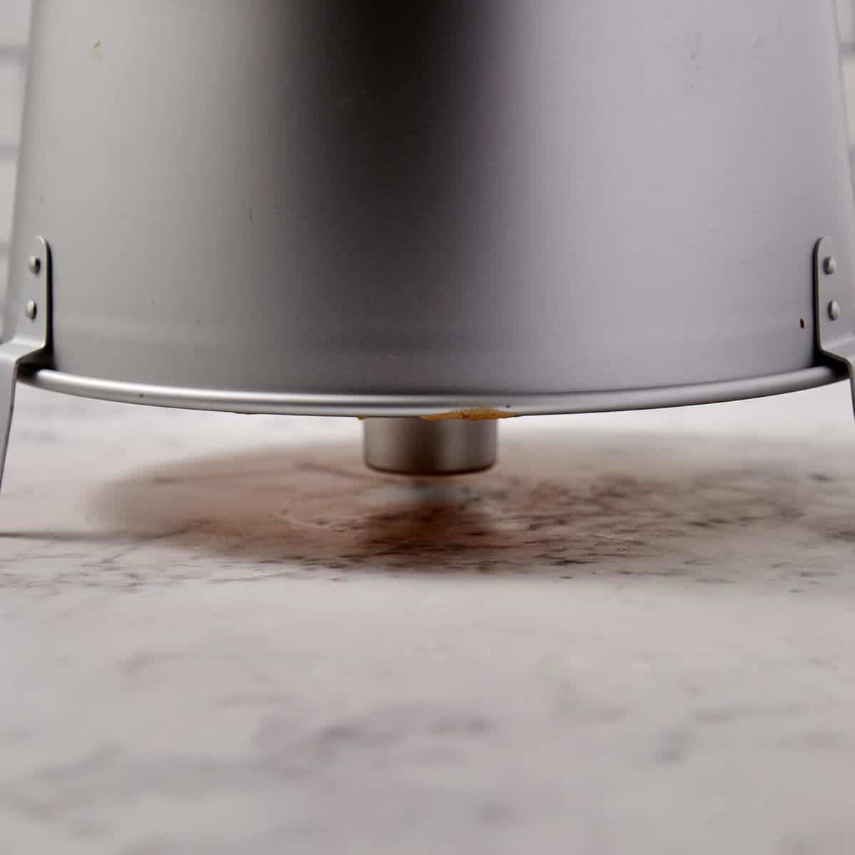 A close up showing the angel food cake in the pan flipped over on the counter.