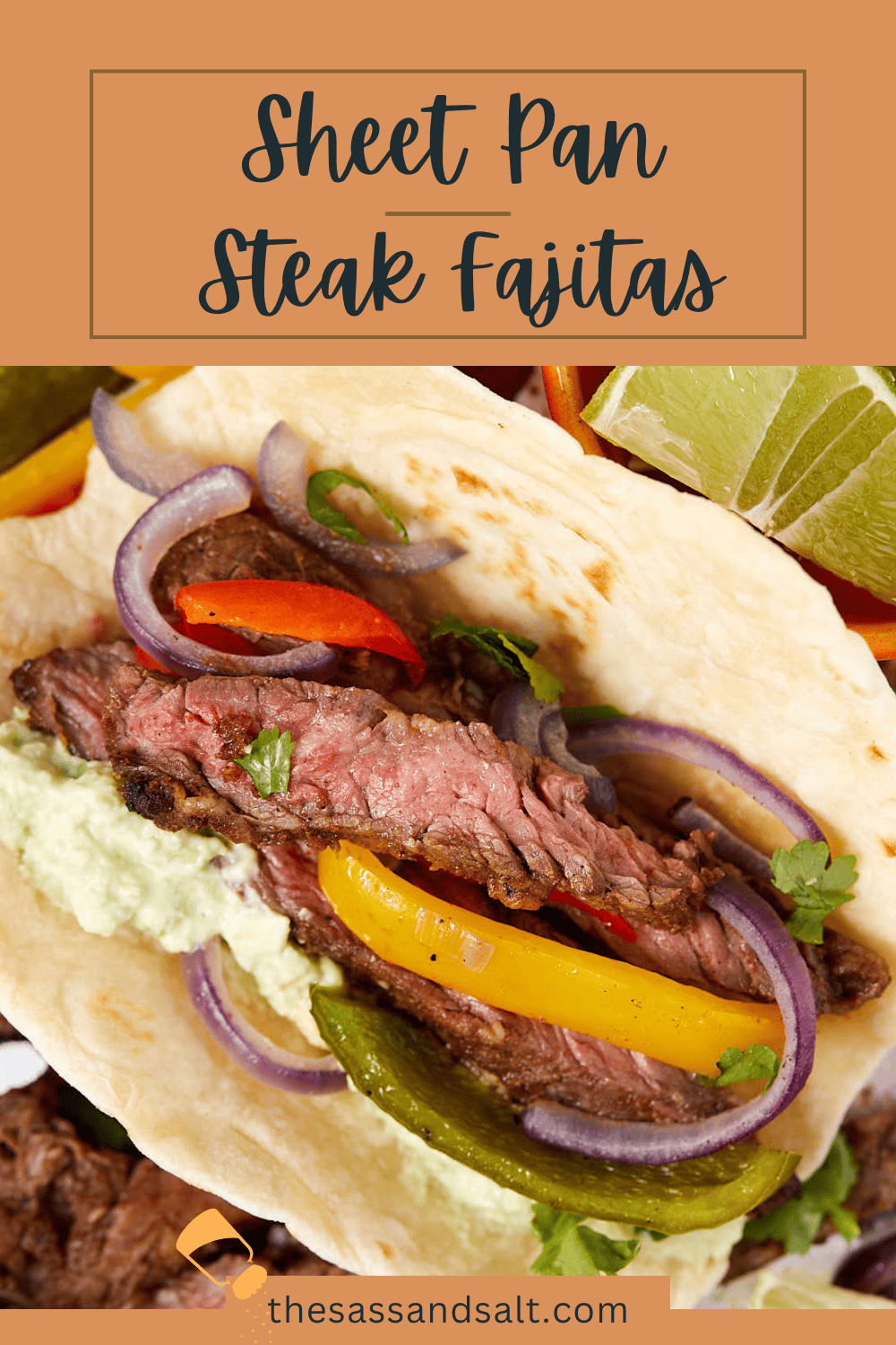 A close-up of a sheet pan steak fajita on a tortilla, topped with slices of steak, red and yellow bell peppers, red onions, and guacamole. Lime wedges are visible in the background. Text at the top reads "Sheet Pan Steak Fajitas.