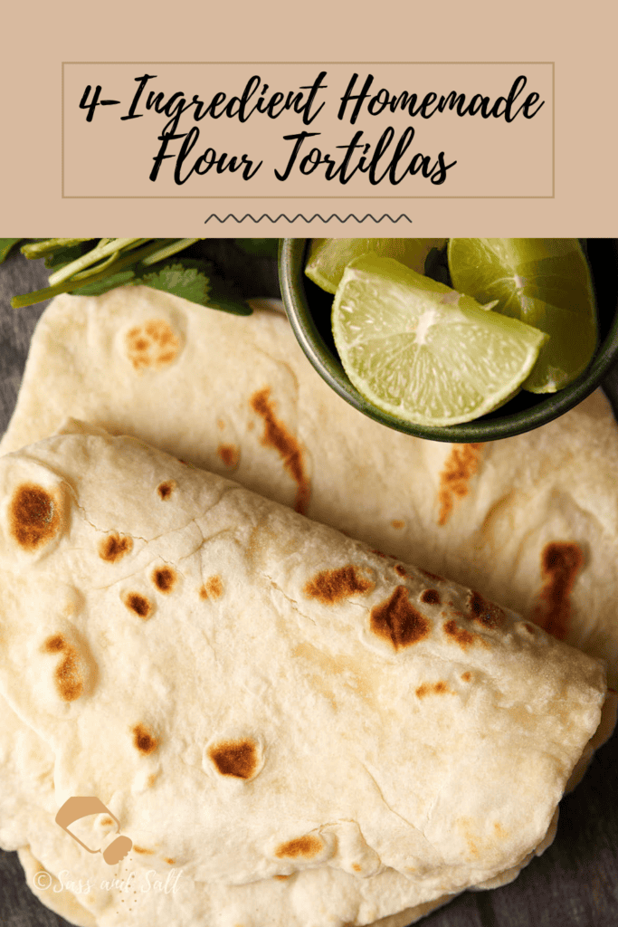 A stack of homemade flour tortillas on a wooden surface with a bowl of lime wedges and cilantro garnish. A text overlay at the top reads, "4-Ingredient Homemade Flour Tortillas.