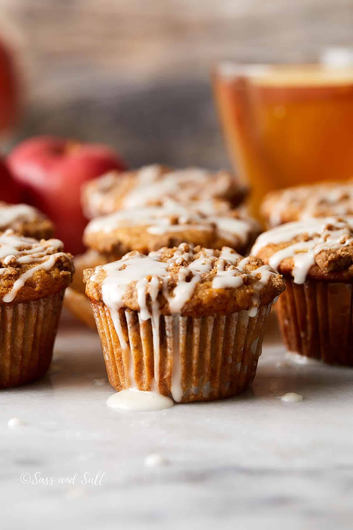 Apple cider streusel muffins on a light surface.