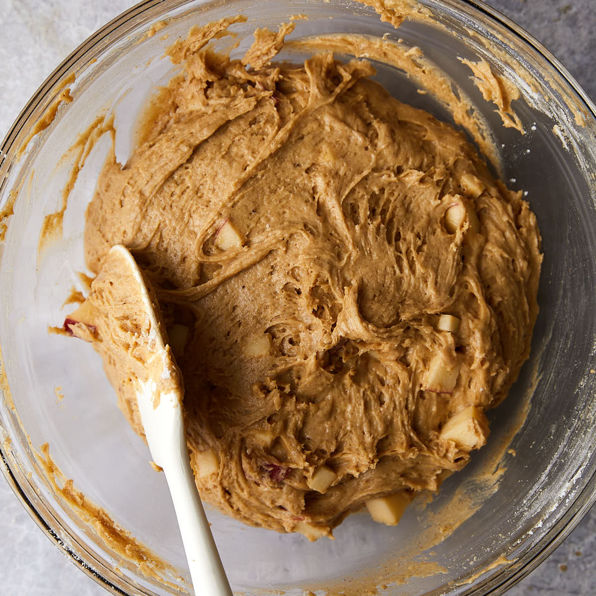 Apple chunks folded into apple cider muffin batter.