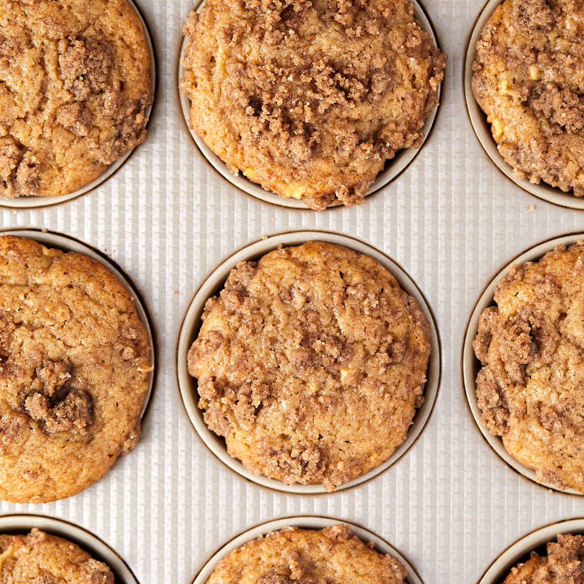 Baked apple cider muffins with streusel in the pan.