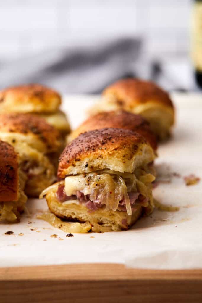 A hand holding a sandwich with meat and cheese