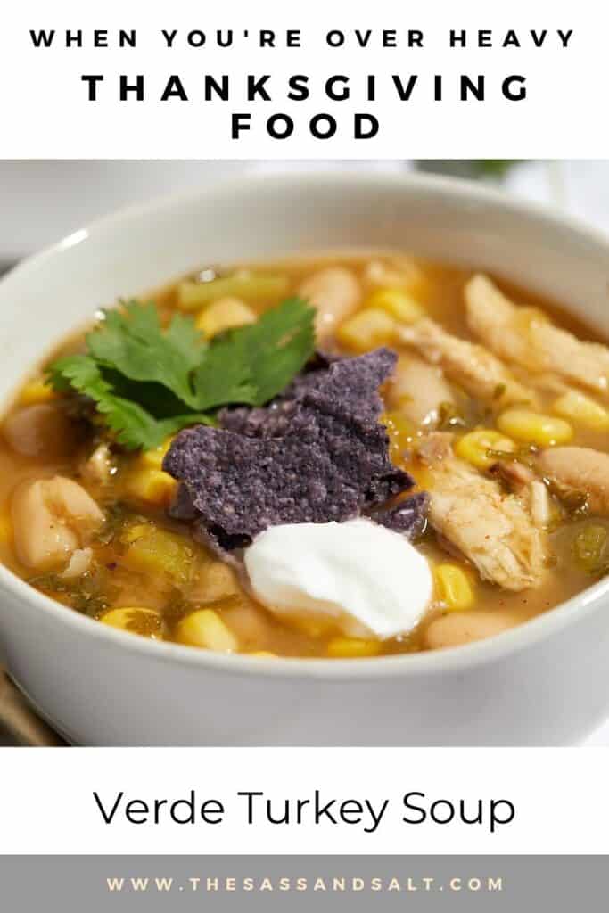 A bowl of verde turkey soup topped with sour cream, purple tortilla chips, and cilantro, featuring white beans, corn, and shredded turkey in broth. Text above reads, “When you’re over heavy Thanksgiving food.”.