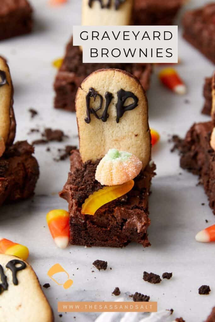 A graveyard brownie decorated with a cookie tombstone labeled "RIP," gummy candy, and candy corn creates the ultimate Halloween brownie graveyard treat.