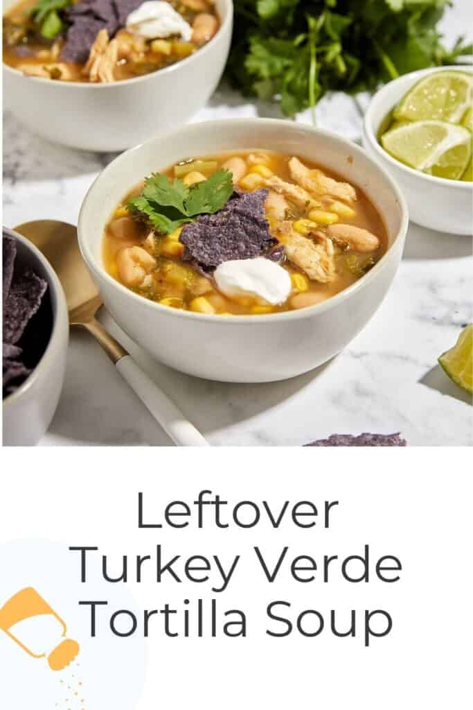 A bowl of turkey verde tortilla soup topped with blue corn tortilla chips, a dollop of sour cream, and cilantro sits beside lime wedges and another bowl, with "Leftover Turkey Verde Tortilla Soup" text below.