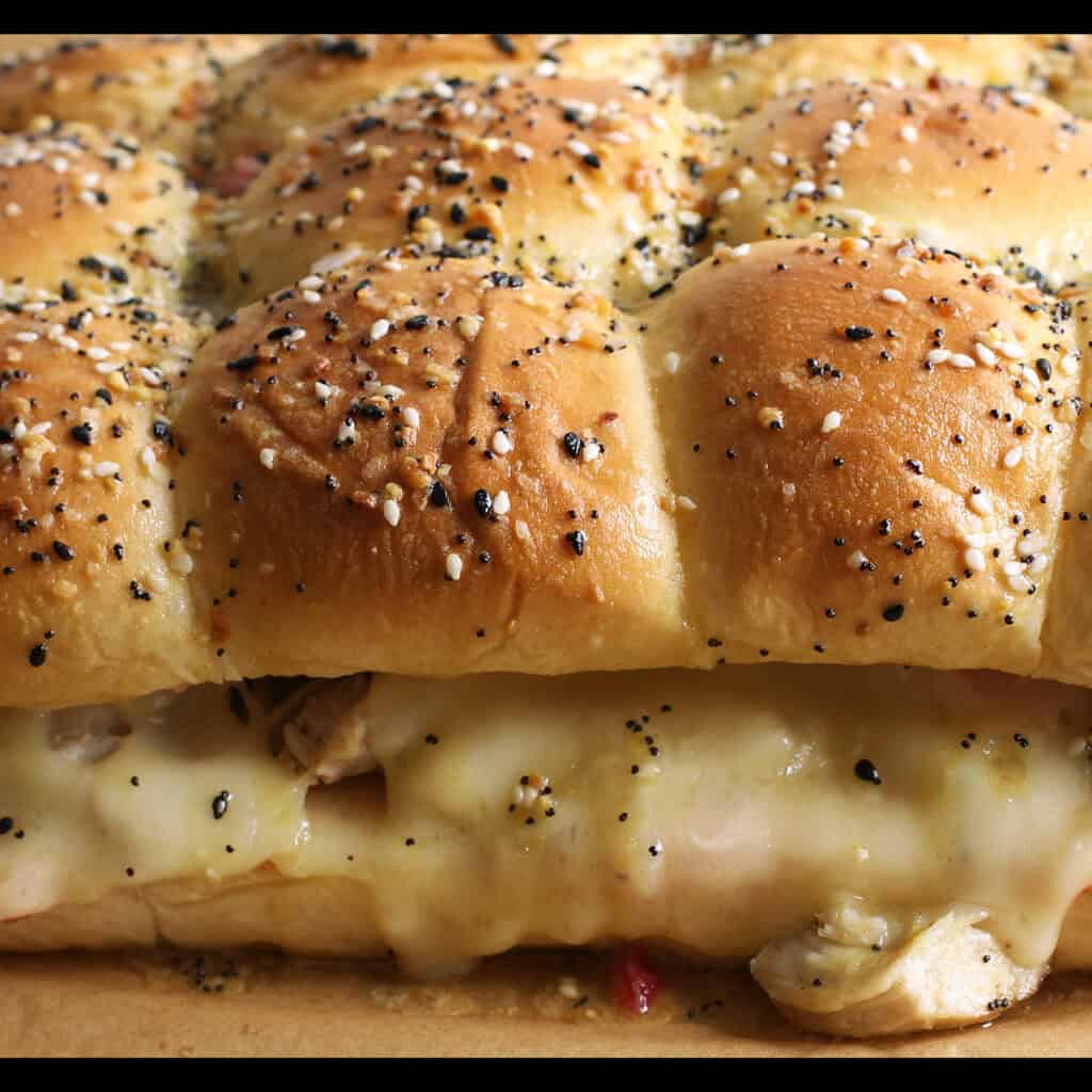 A close up of cranberry turkey sliders with melting cheese.