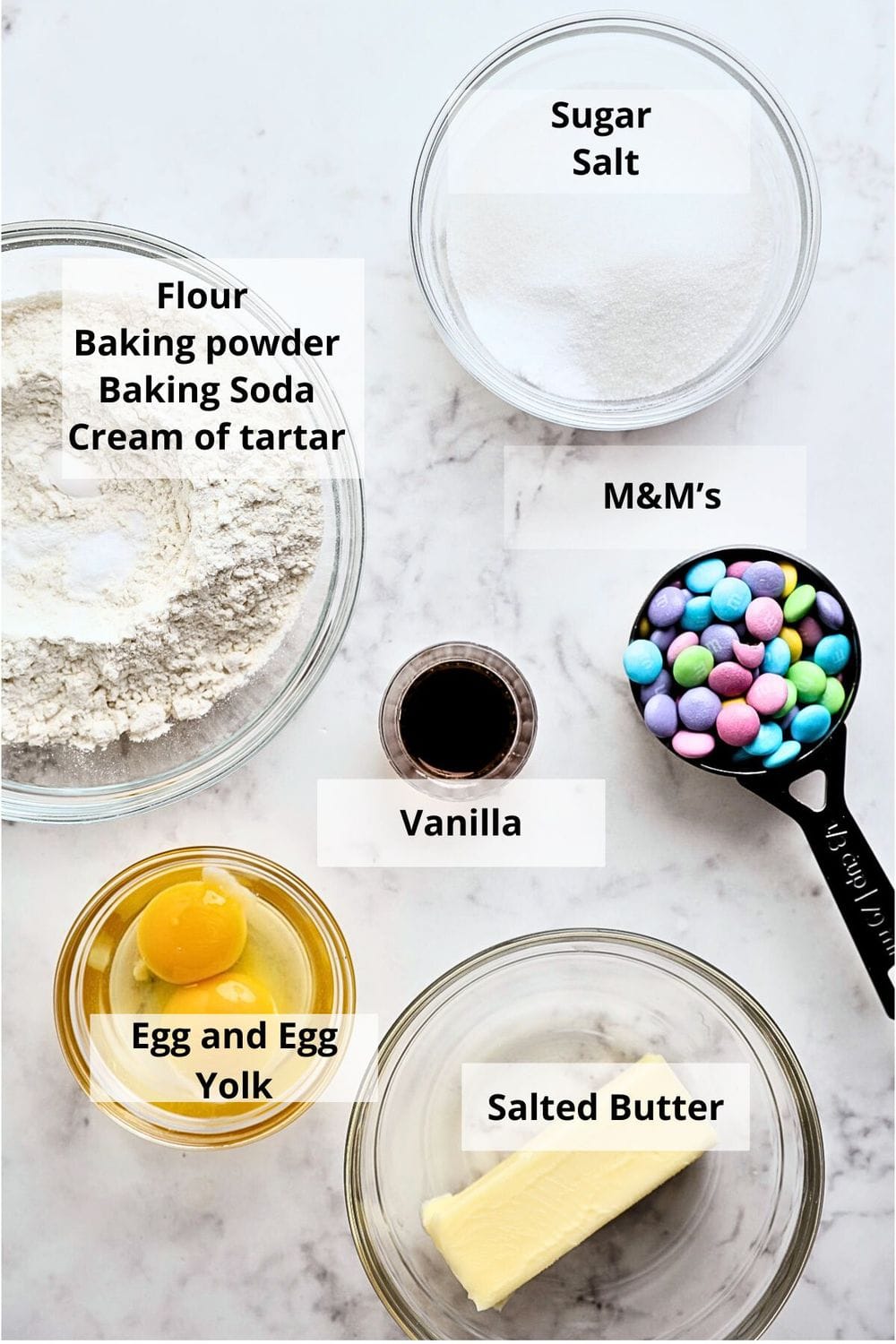 Top-down view of separated baking ingredients on a marble surface. 