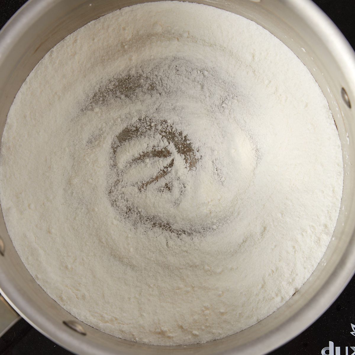 Sugar, cornstarch, and salt whisked together in a saucepan to start homemade banana pudding.