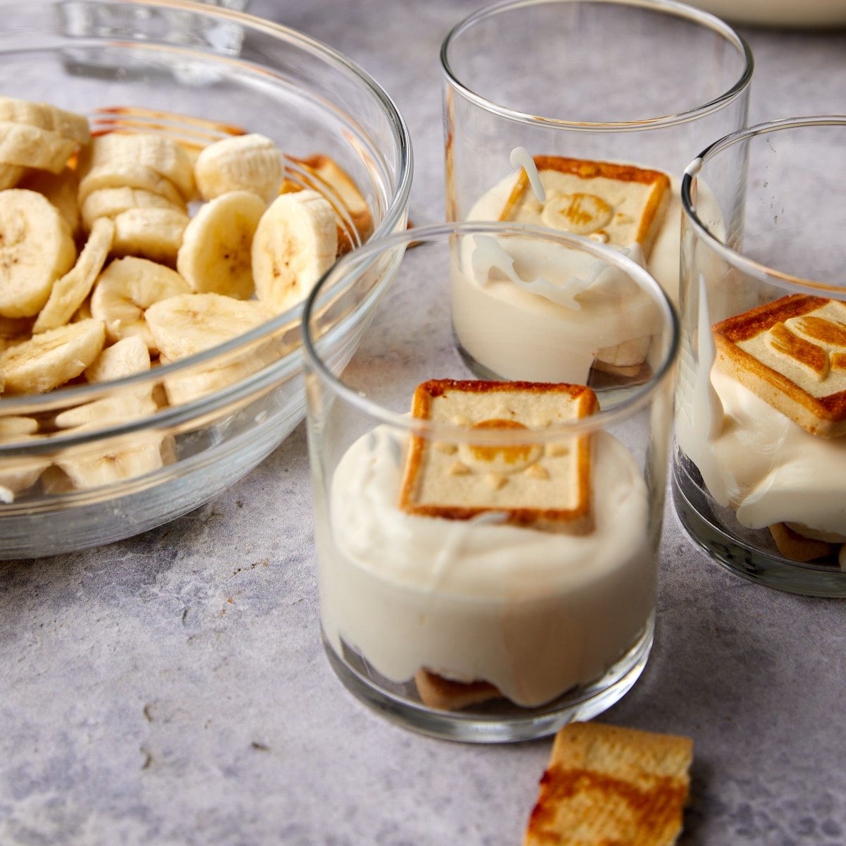 Layered banana pudding cups with cookies, bananas, and pudding.
