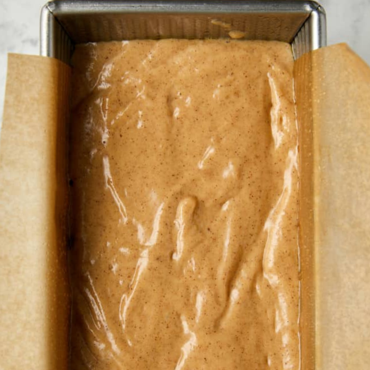Apple cider donut loaf cake batter in loaf pan.