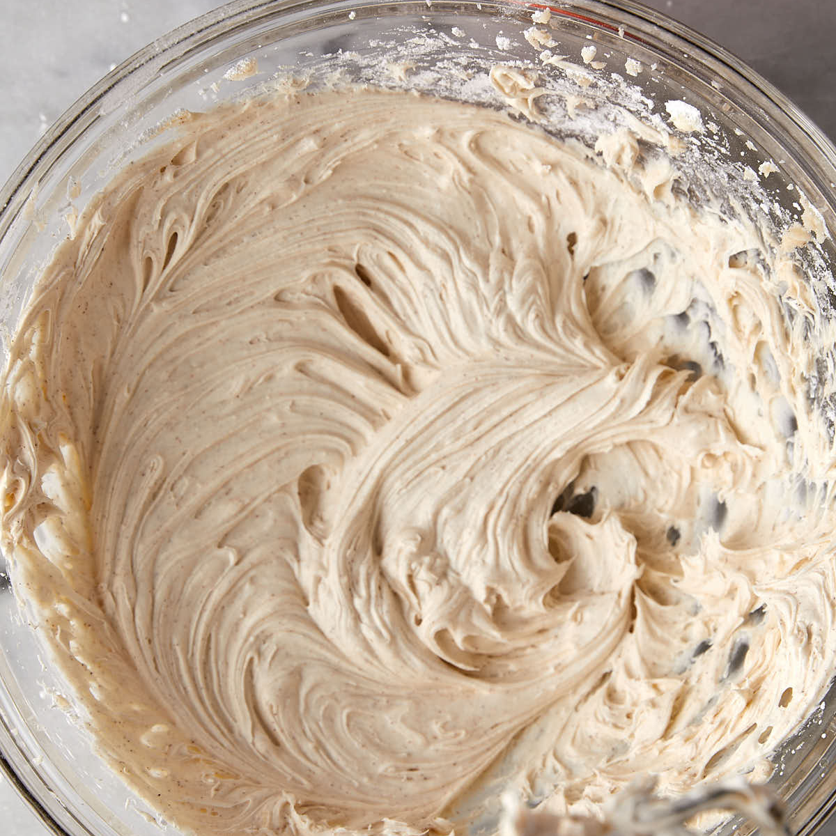 Cinnamon cream cheese filling mixed in glass bowl.