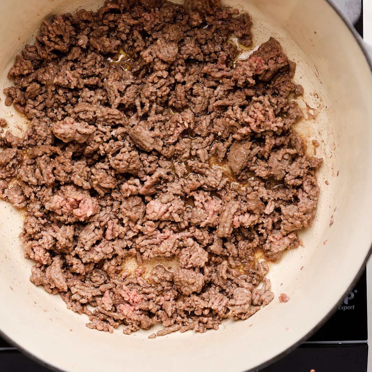 Ground beef browning in a Dutch oven.