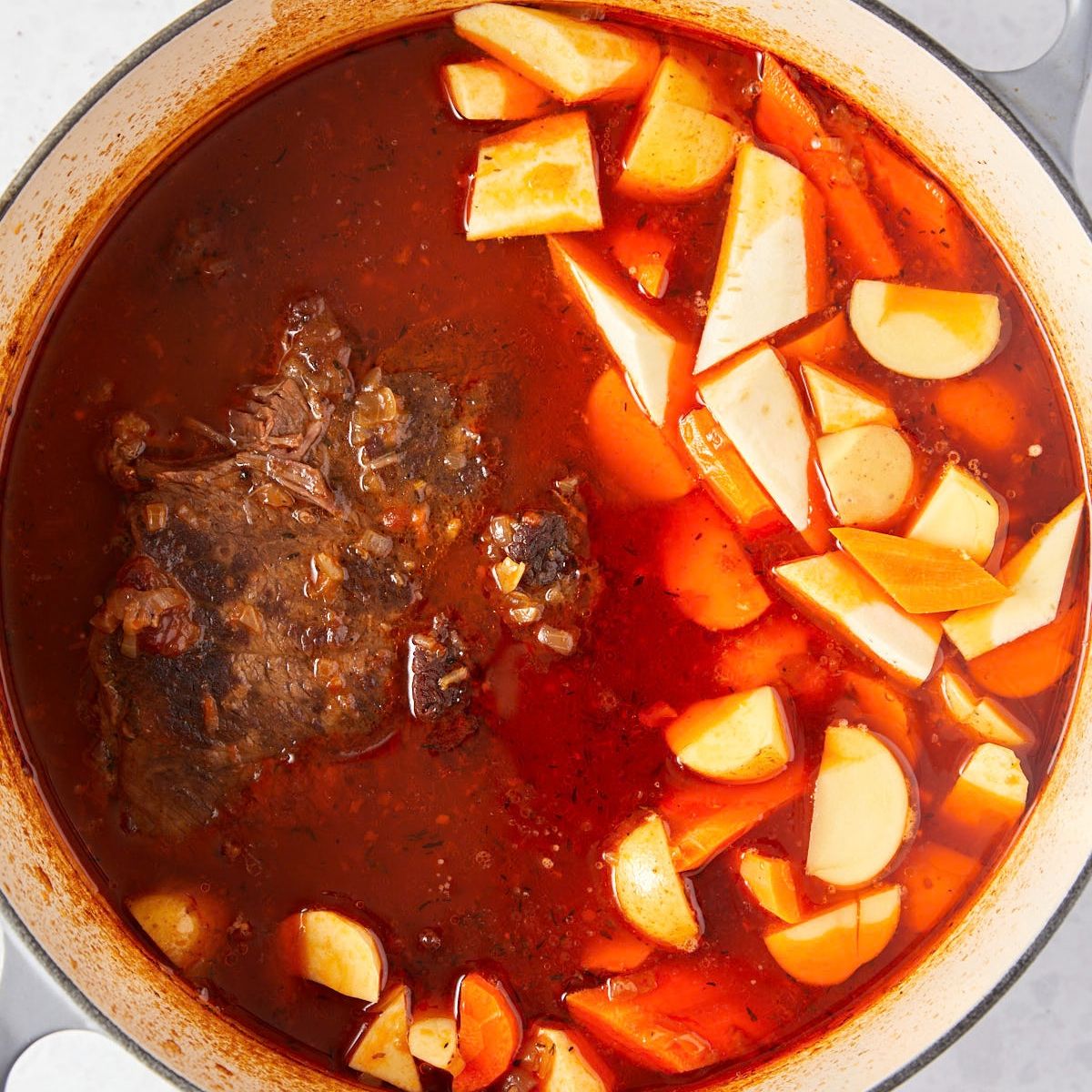Carrots, parsnips, and potatoes added around the braised chuck roast.