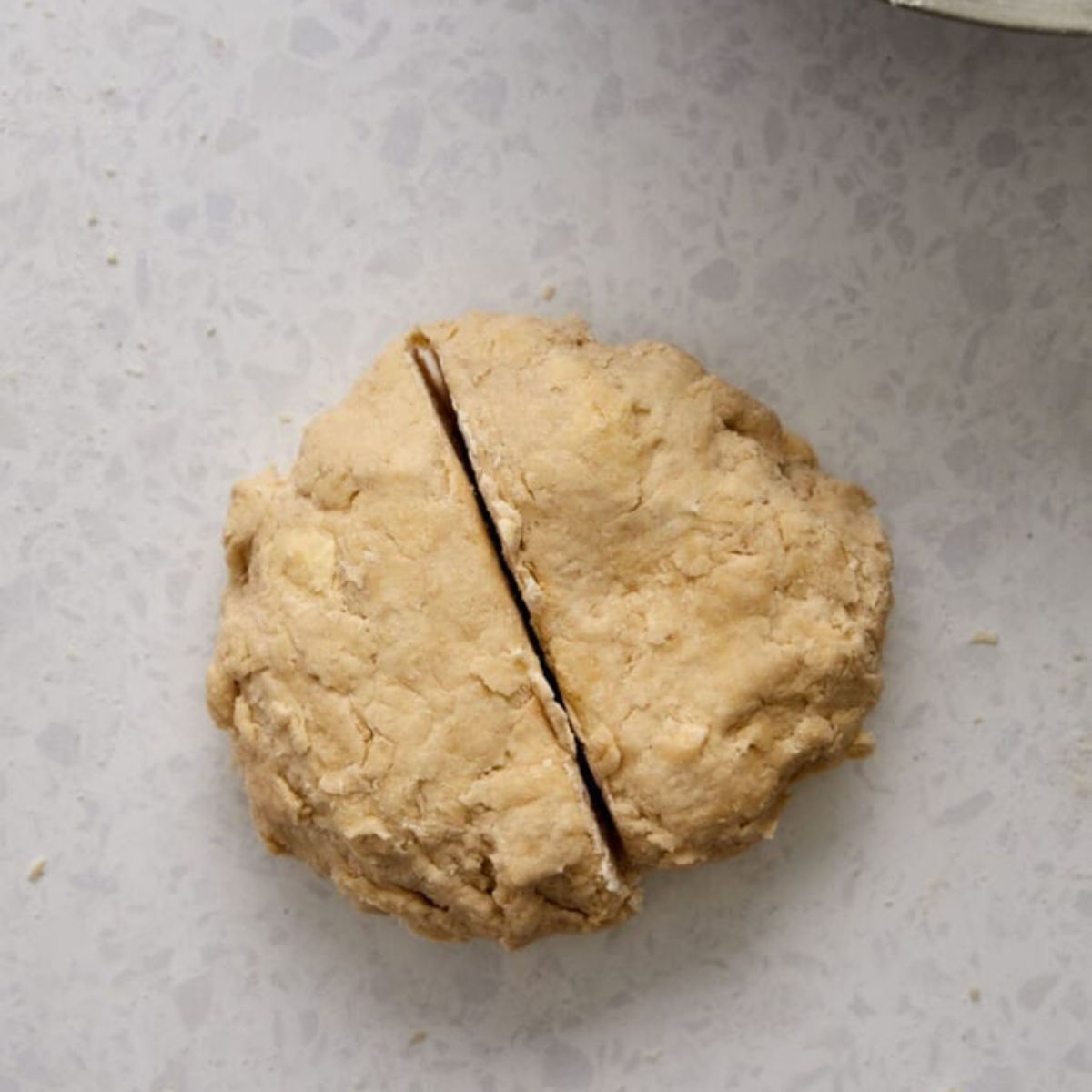 Ball of pie dough cut in half to make 2 crusts.