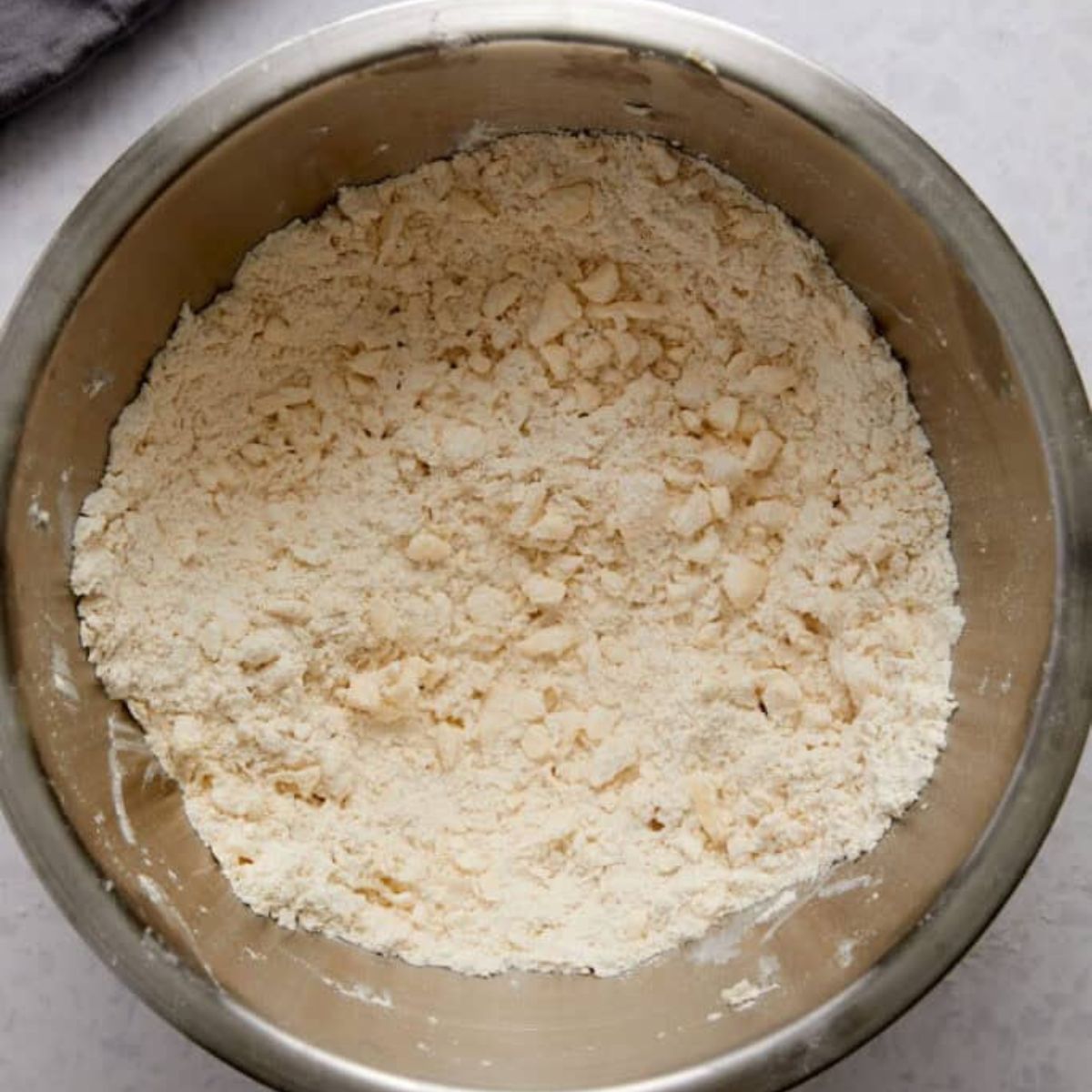Cutting cold butter into flour with a pastry blender.