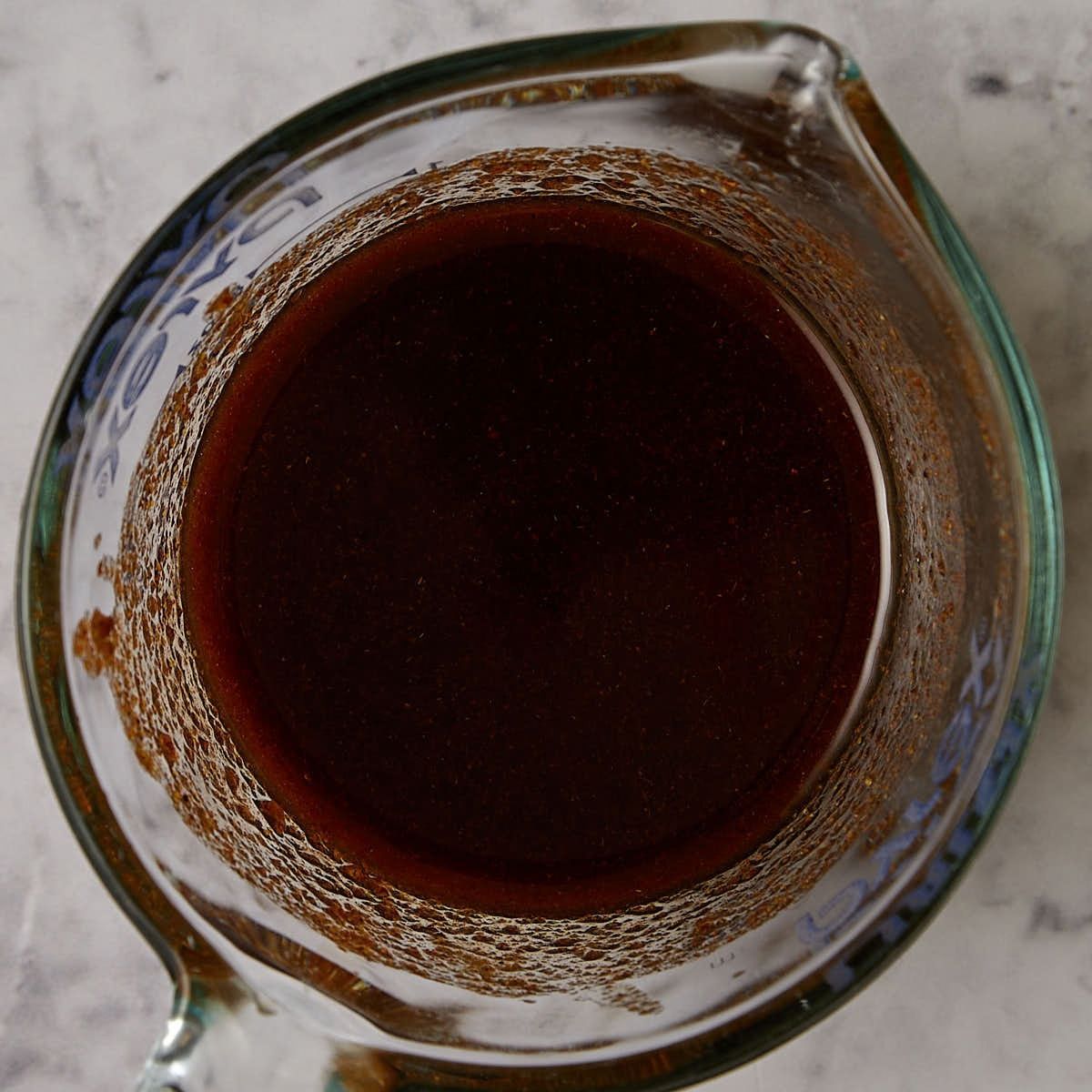 Brown sugar lime fajita marinade whisked together in a glass measuring cup.